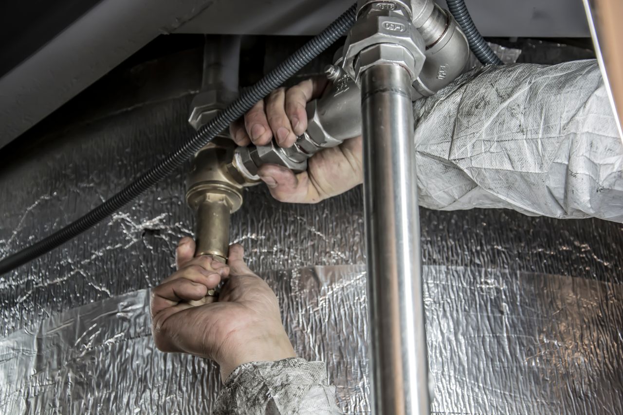 About Close-up of a plumber's hands installing steel pipes indoors, showcasing skilled manual work.